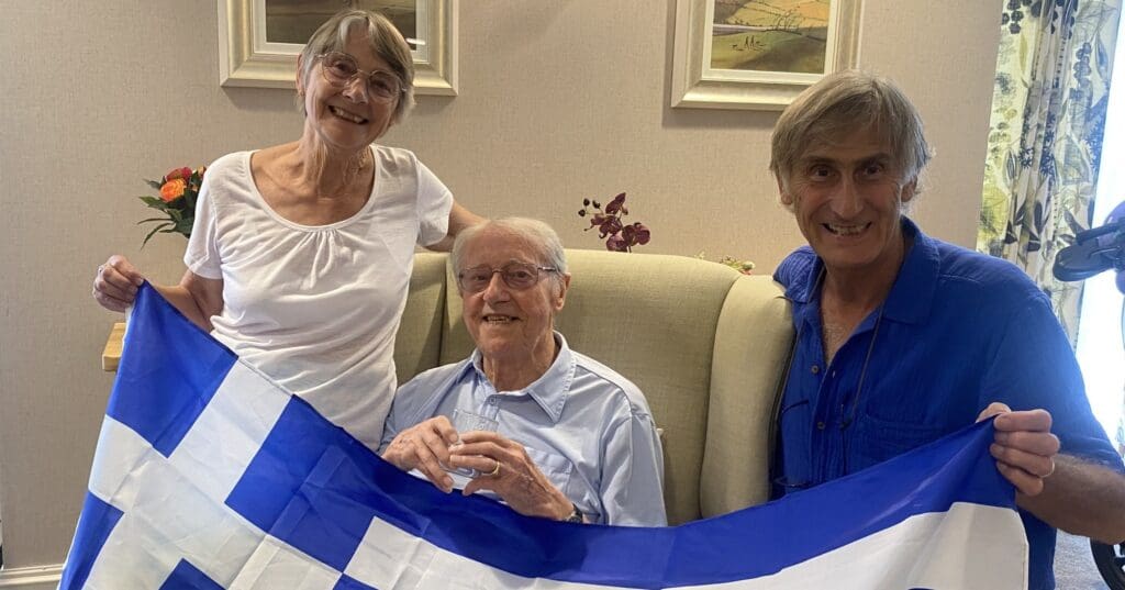 A Lincroft Meadow care home resident with his daughter and son-in-law, celebrating a Greek-themed afternoon.